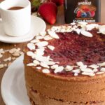 torta al grano saraceno tazzina di caffè e vasetto di marmellata ai frutti di bosco