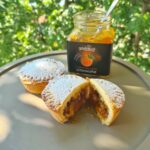 pasticcino diviso a metà e vasetto di confettura all'albicocca aperto