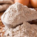 cucchiaio di legno riempito con farina di grano saraceno macinata