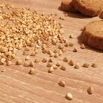 chicchi di grano saraceno e frollini appoggiati su tavolo in legno