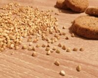 chicchi di grano saraceno e frollini appoggiati su tavolo in legno