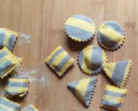 ravioli bicolore al mirtillo sparsi su spianatoia