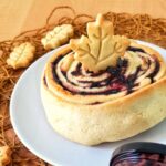 crostata arrotolata con confettura al mirtillo e biscotti a forma di foglia